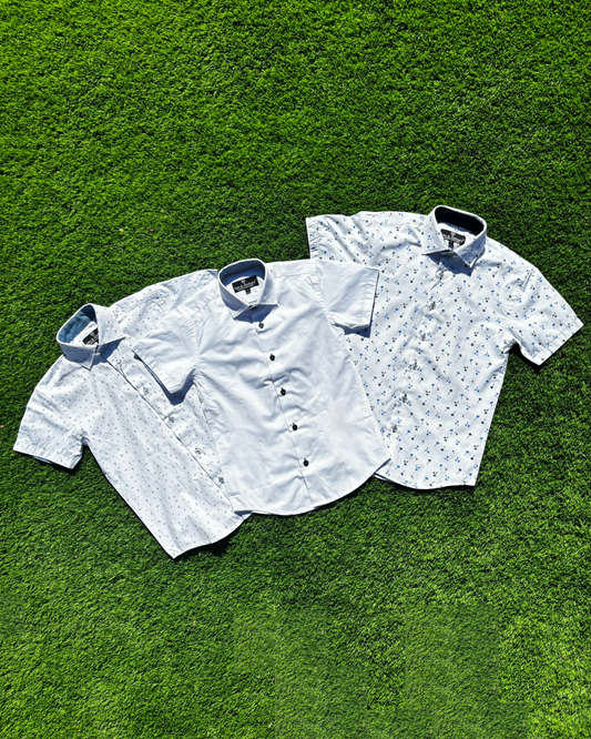 Three short-sleeve shirts on a green grass background