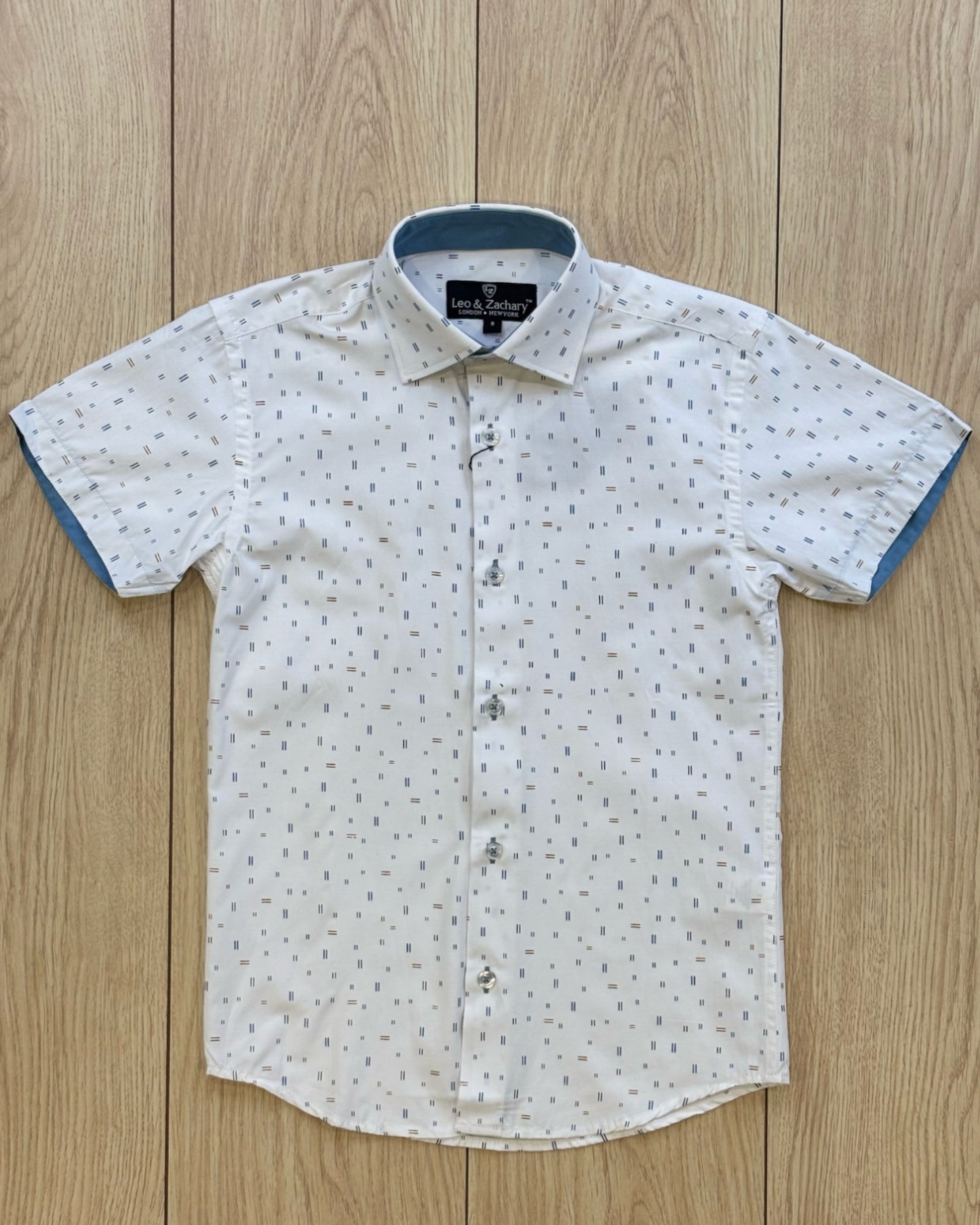 Short-sleeve shirt with a subtle pattern on a wooden surface