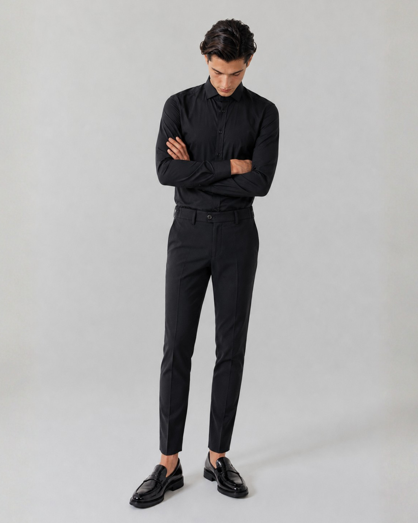 Teenager wearing a black shirt and pants on a grey background