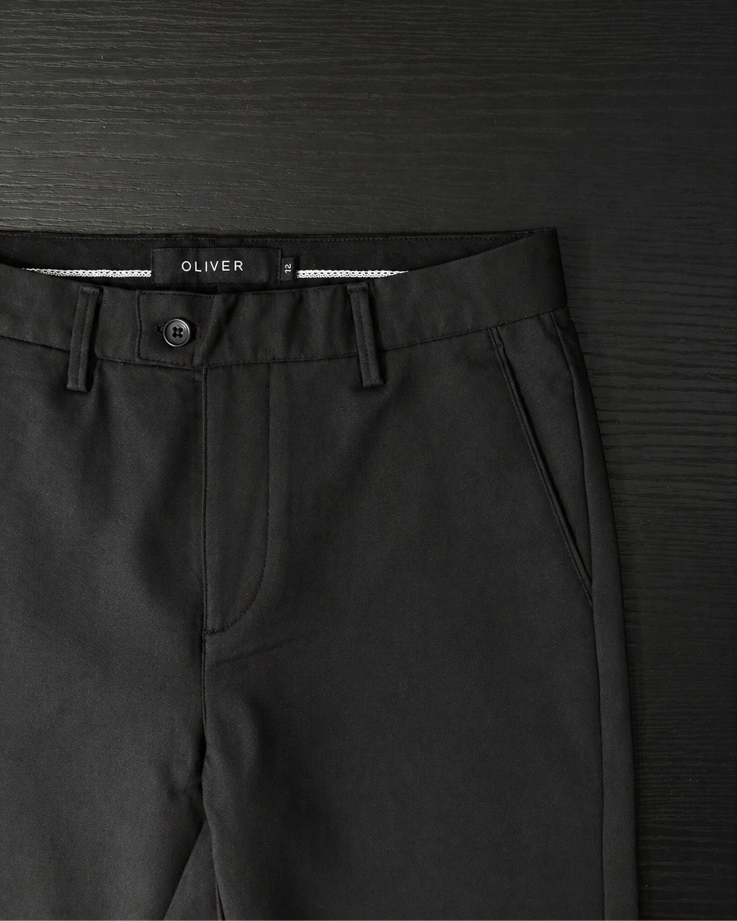 Boys black stretch dress pants waistband close up button and belt loops detail