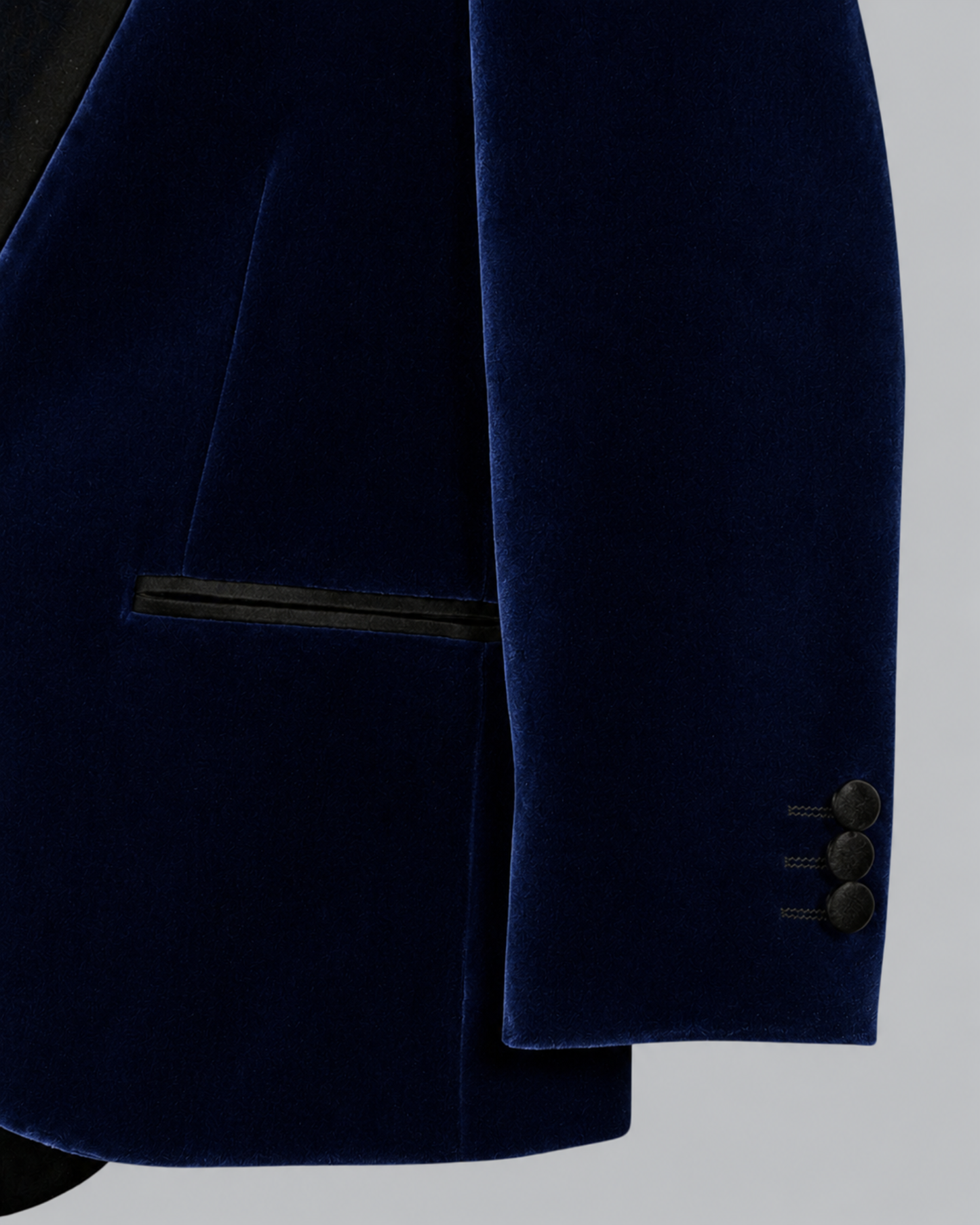 Close-up of a navy blue velvet blazer jacket showing the fabric texture.