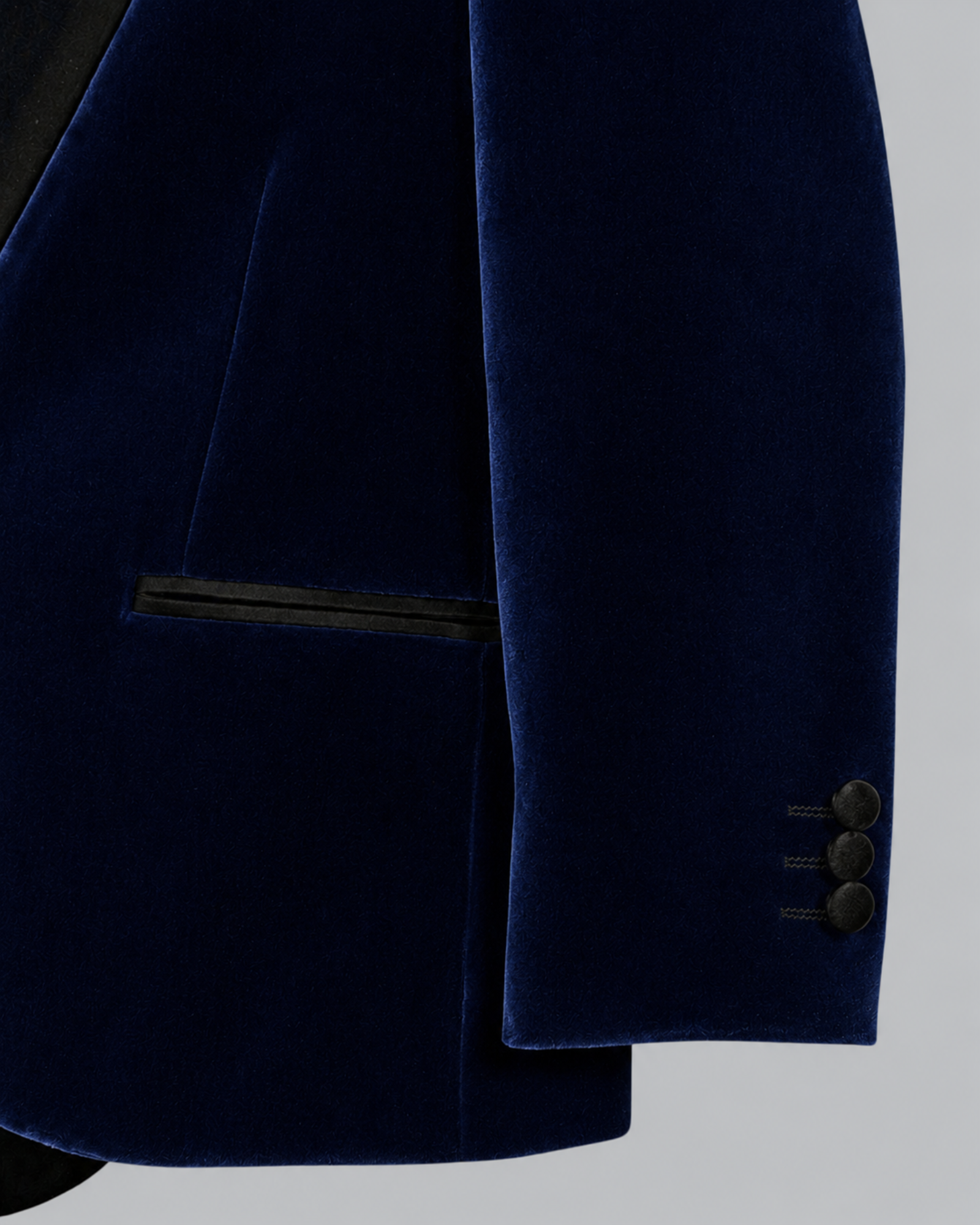 Close-up of a navy blue velvet blazer jacket showing the fabric texture.