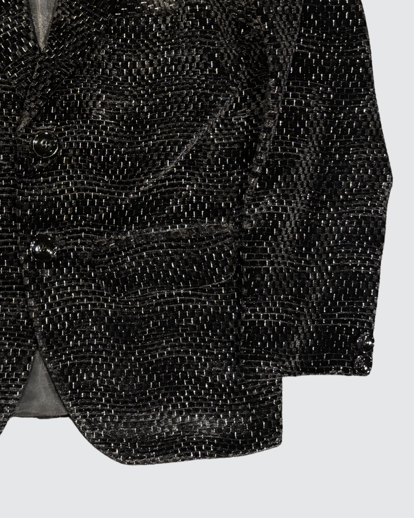 Detailed view of black textured jacquard blazer fabric with subtle shimmer pattern for boys party wear
