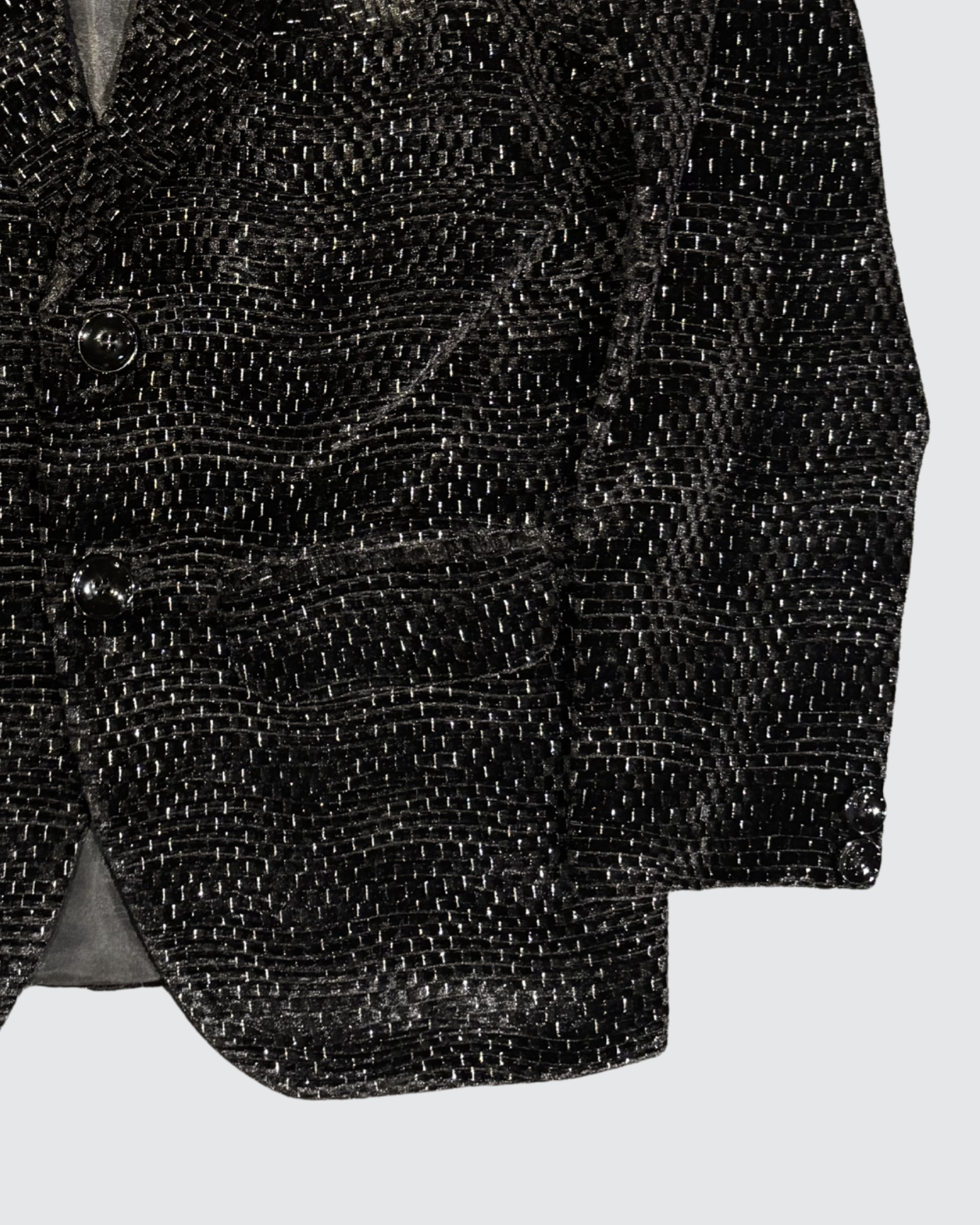 Detailed view of black textured jacquard blazer fabric with subtle shimmer pattern for boys party wear