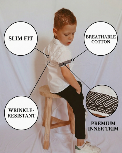 boy wearing white shirt and black chinos sitting on a chair
