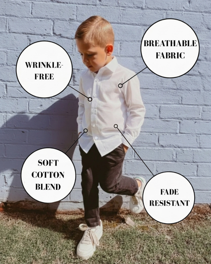 boy wearing white dress shirt with black chinos standing against a wall