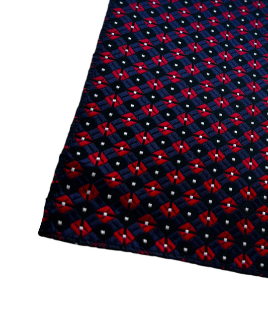 Navy blue pocket square with red geometric pattern on a white background