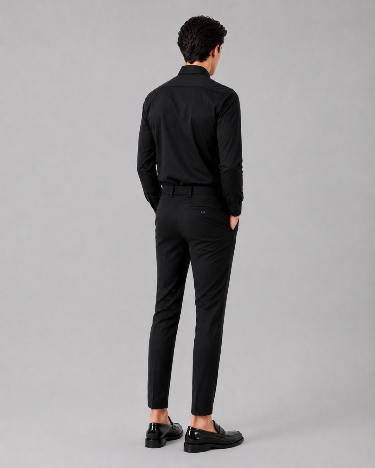 Teenager wearing a black suit on a gray background