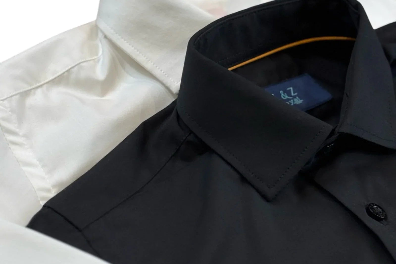 Close up of boys lack and white dress shirt. featuring the collar and top buttons.