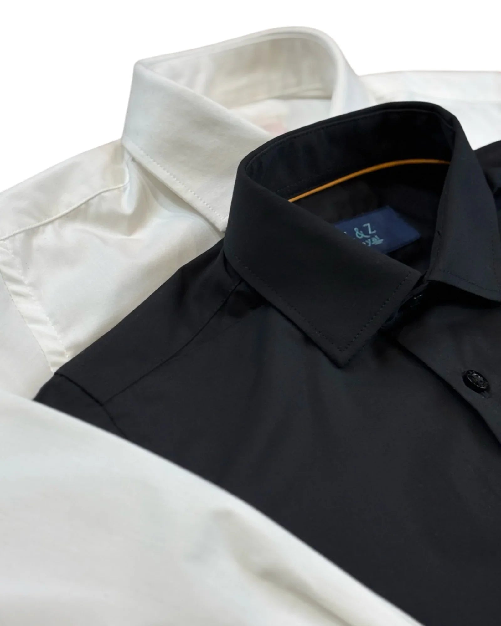 Close up of boys white and black dress shirts showing slim fit collar and smooth wrinkle free fabric