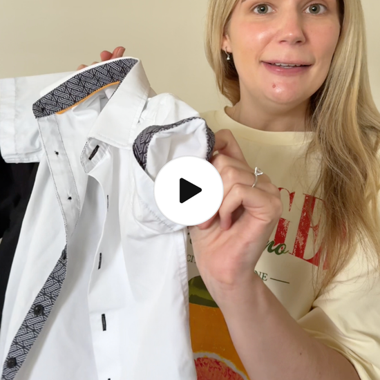 Mum talking about kids white short sleeves shirt, and giving her opinion on it as well as describing features, and details.