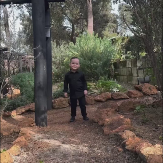 young boy wearing black shirt and black chinos running in  4 different areas
