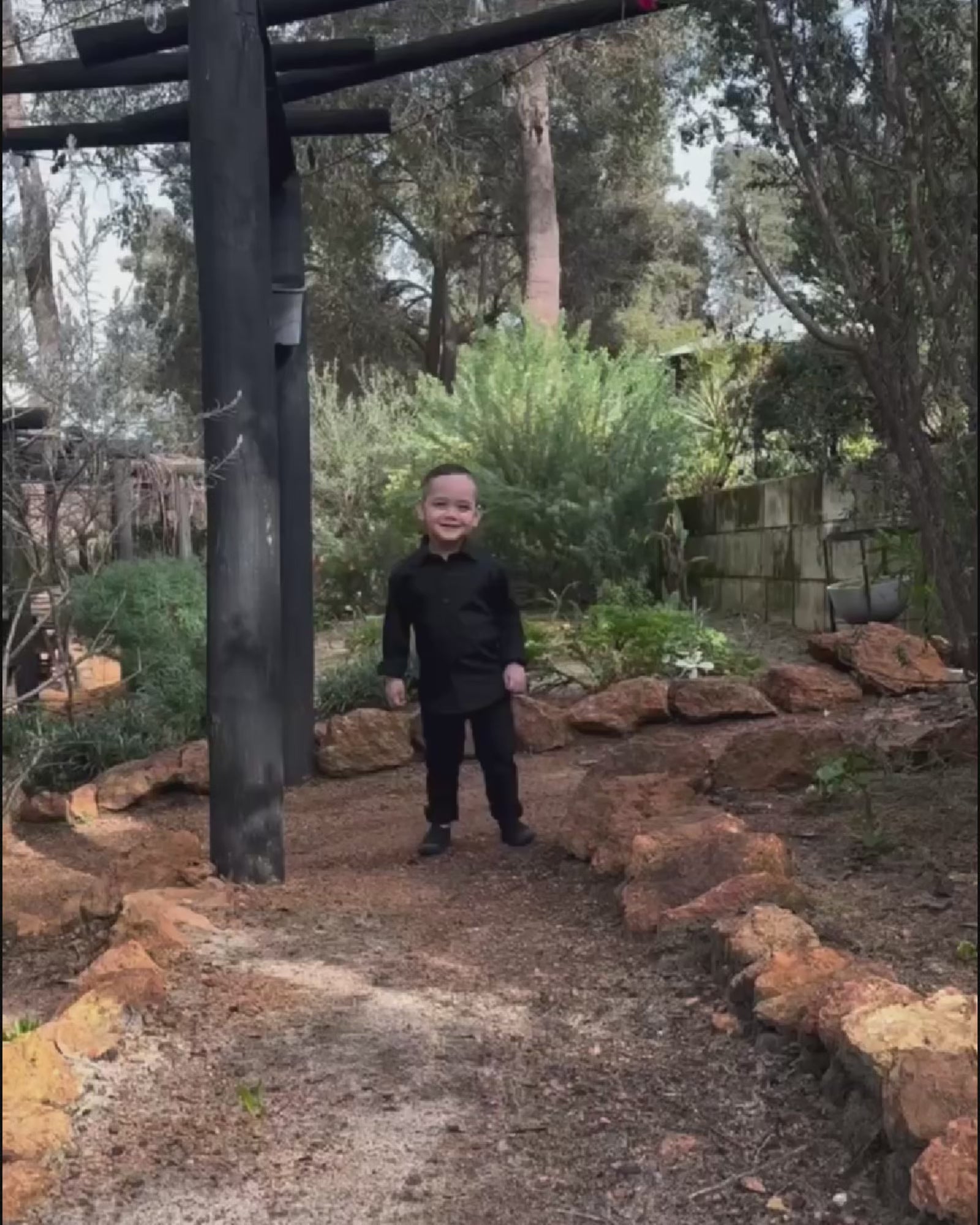 young boy wearing black shirt and black chinos running in  4 different areas