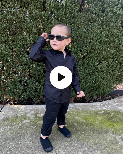 young boy wearing black shirt and black chinos running in  4 different areas